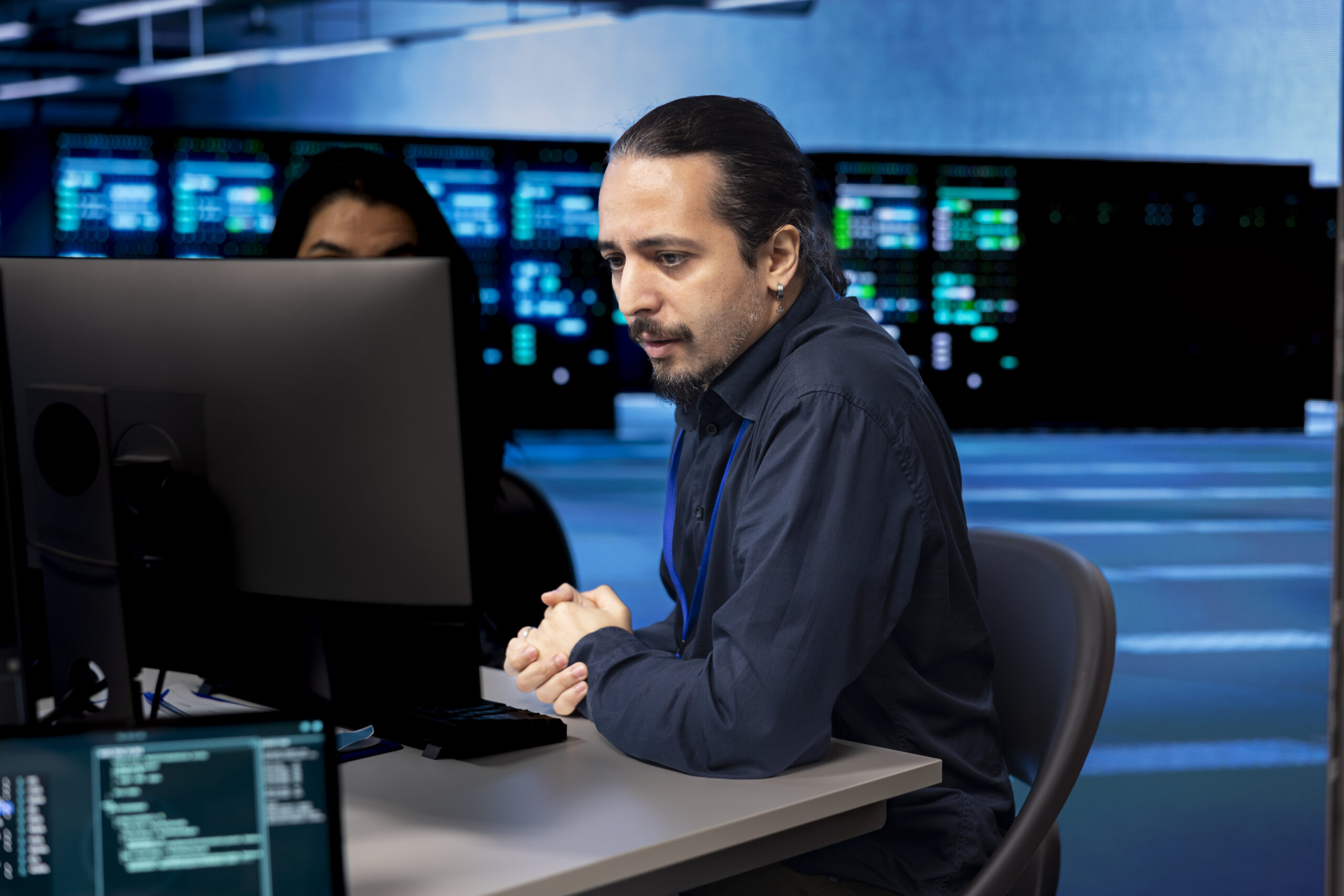 Computer scientists in data center updating systems, protecting servers from damaging software vulnerabilities. Coworkers looking for errors causing infrastructure to slow down